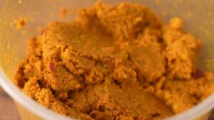 A close-up of homemade Khao Soi curry paste in a container